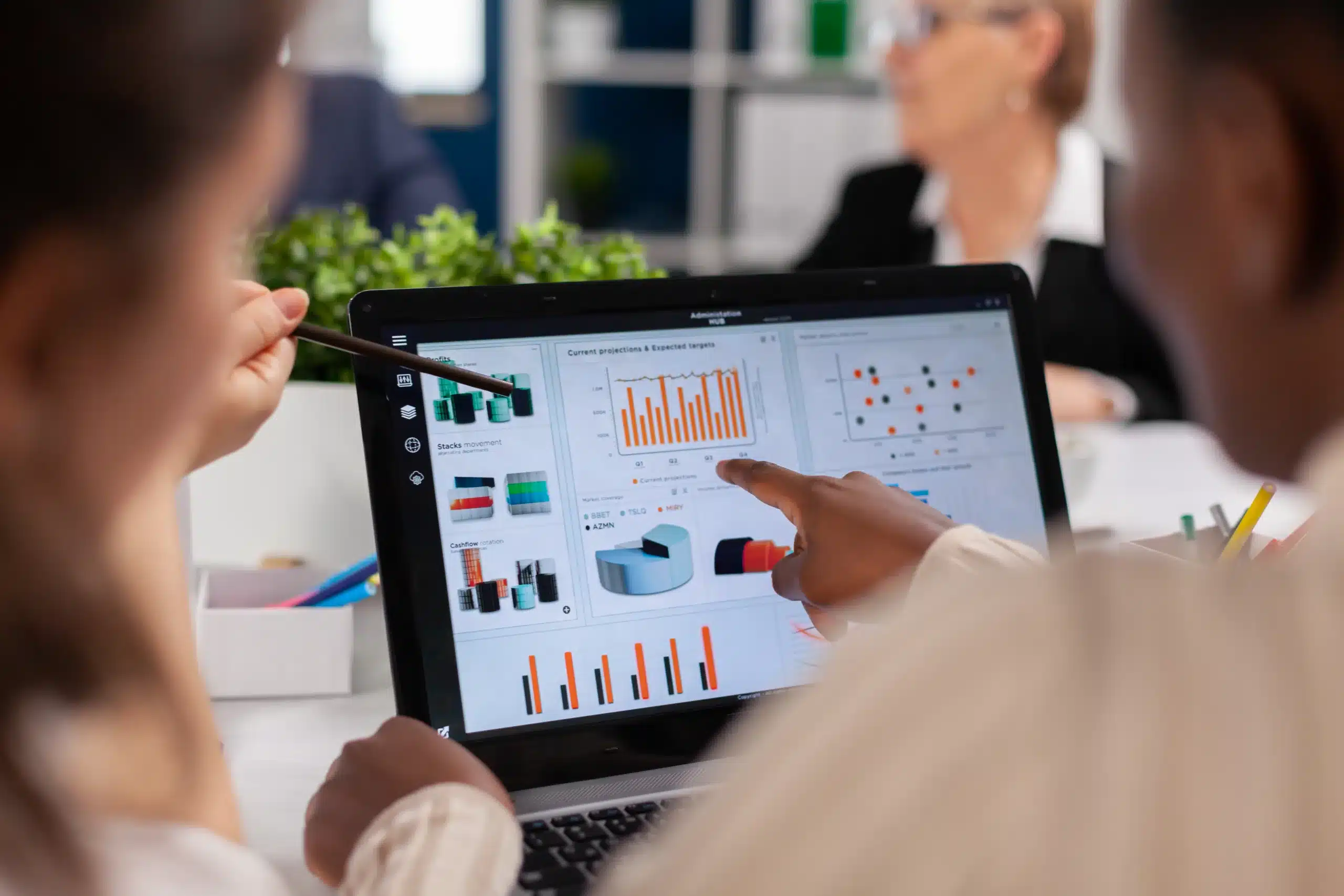 Professionals reviewing business performance charts on a laptop